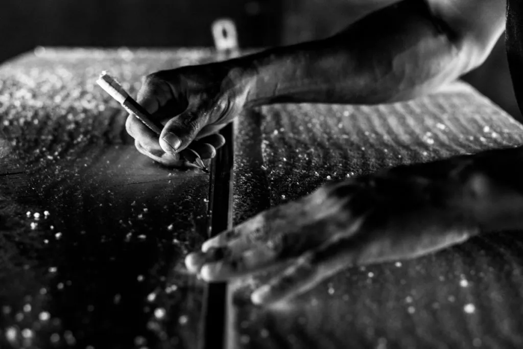 A shaper at work on a blank in a small bay