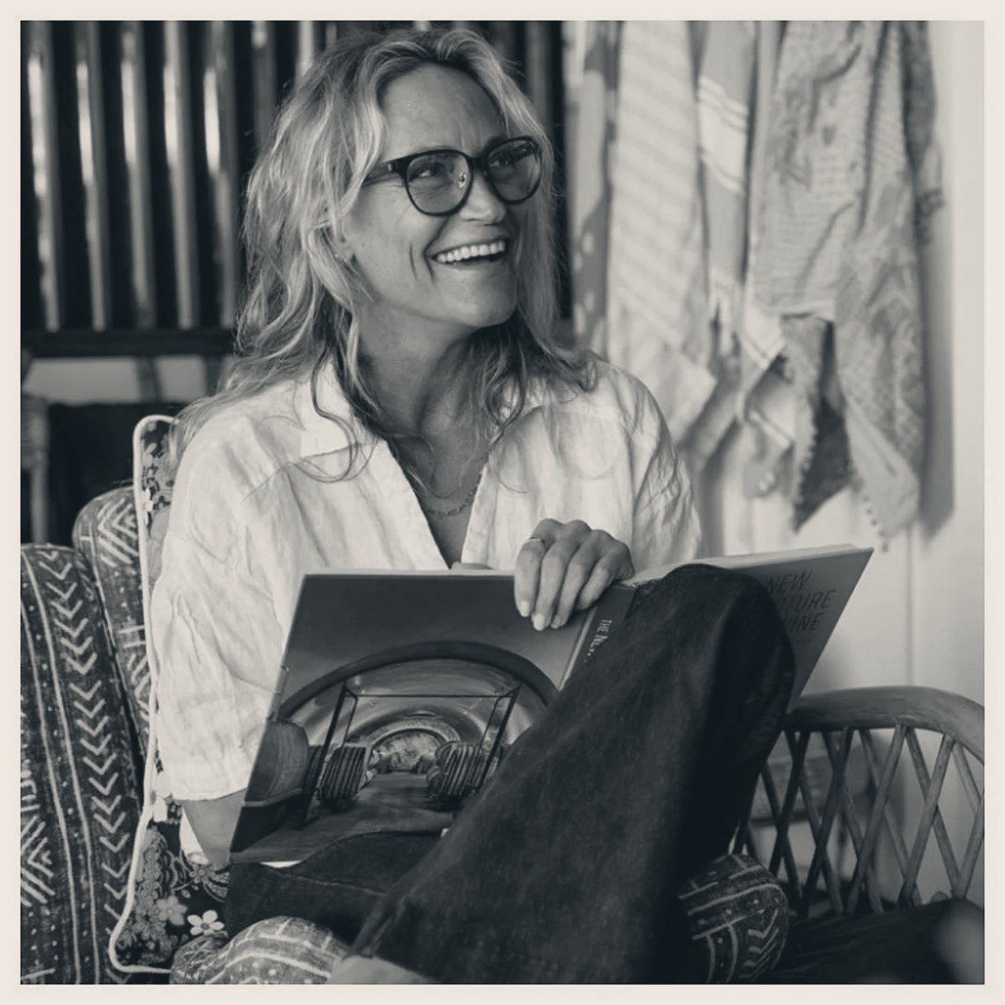 Lisa Andersen seated with a book, laughing