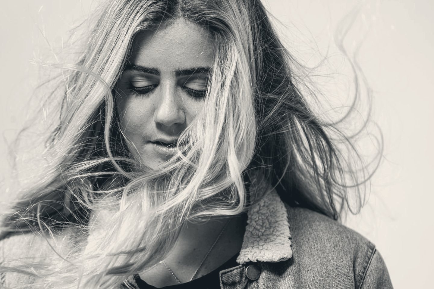 Caroline Marks, wind-blown black-and-white portrait, eyes closed